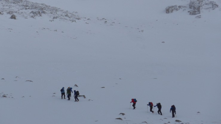 Party heading up to windy Col on firm snow - Sneachda